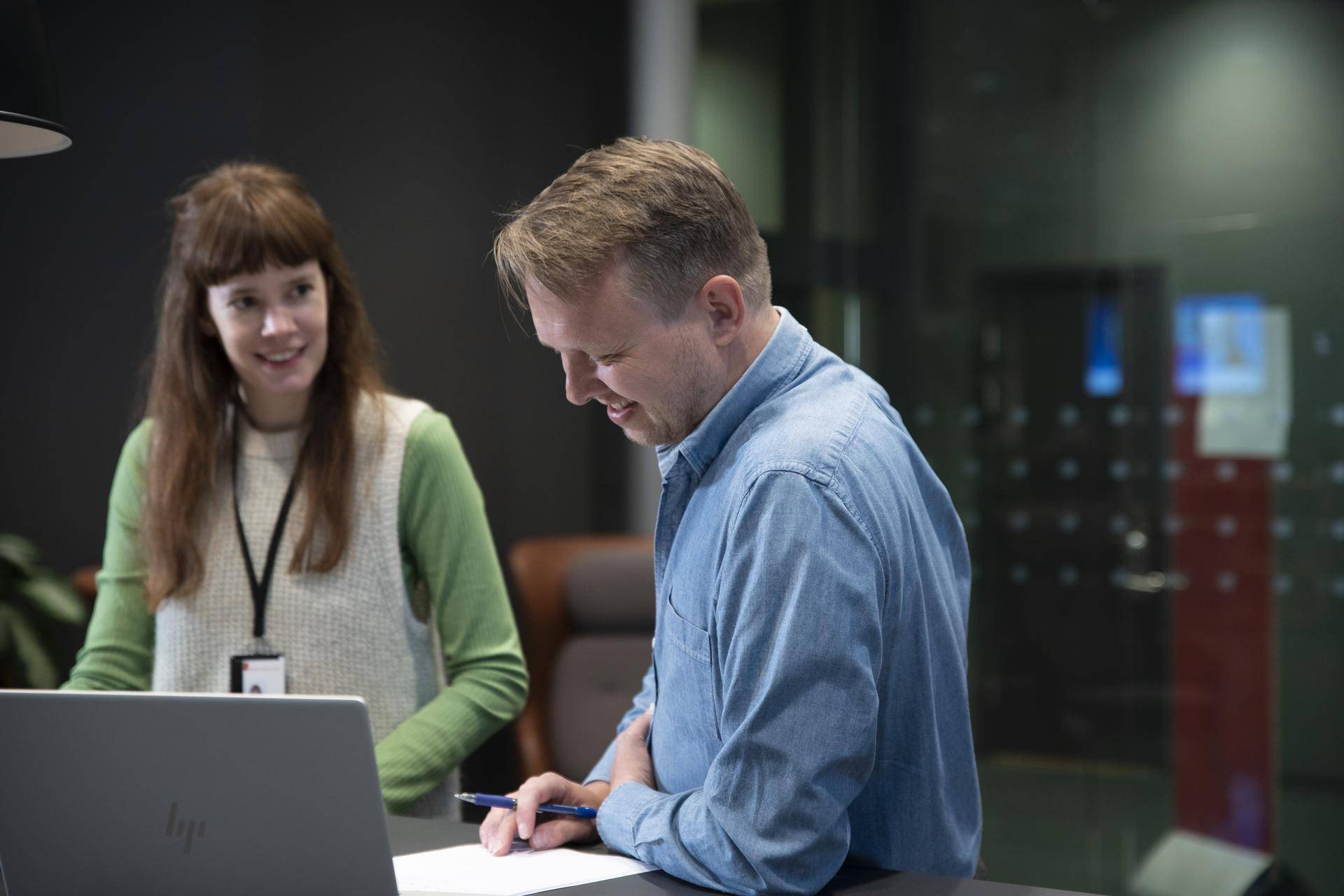Veiledningssituasjon med to personer ved en skjerm og skranke
