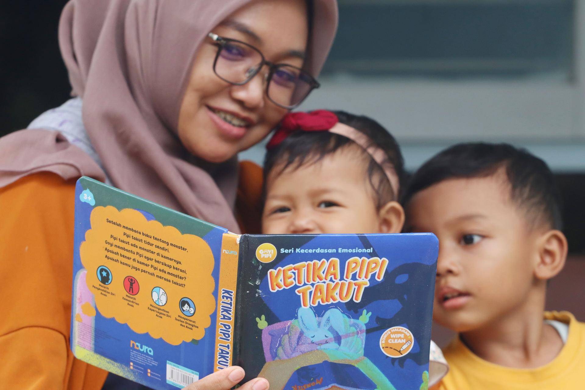 Kvinne leser høyt for to barn på fanget